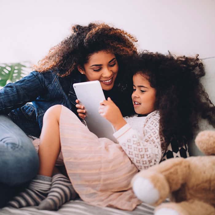 Mom and daughter reading together on ipad